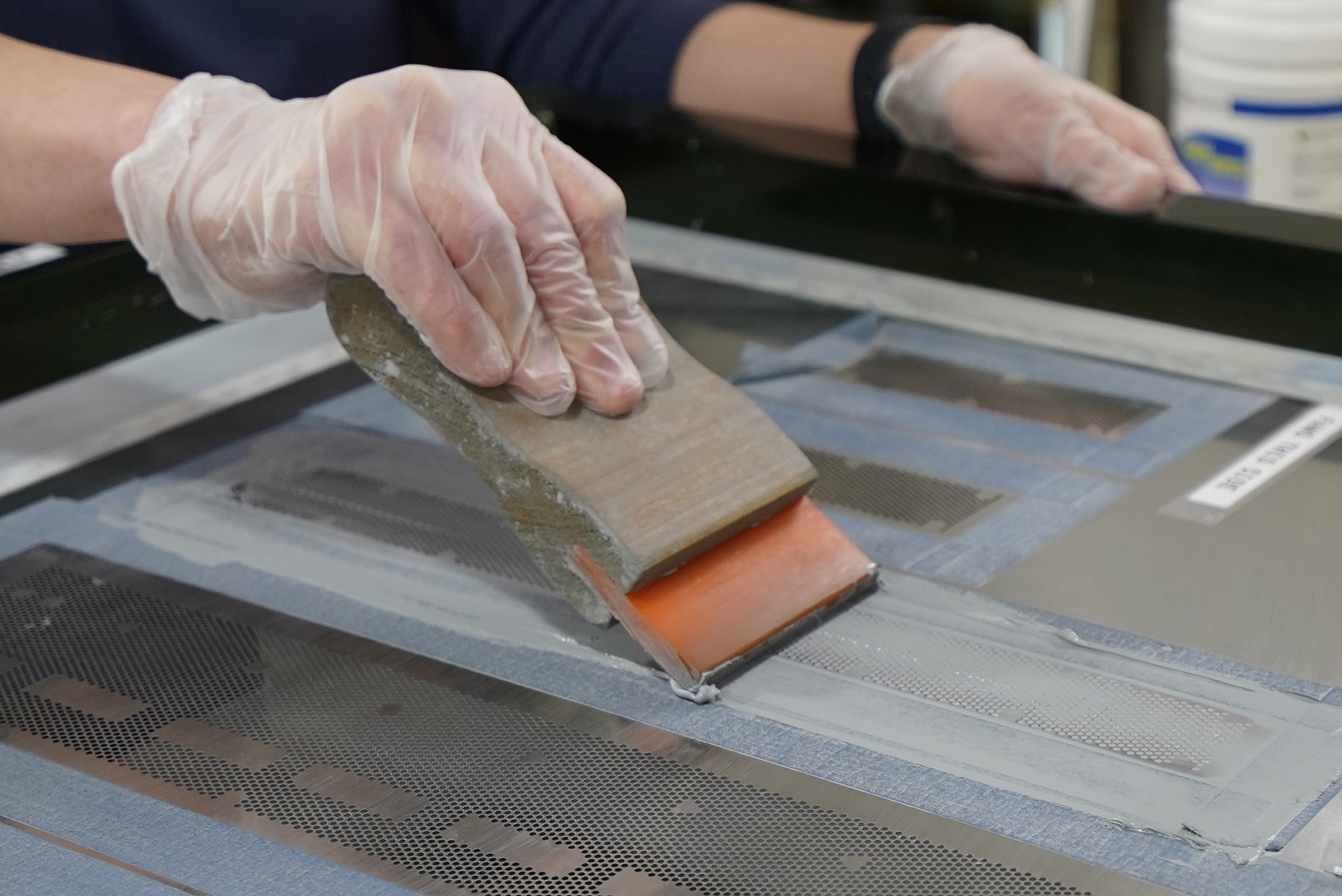 Fig 15. TIM printing with stencil. Squeegee is moved across the stencil with the heatsink underneath. Surface finished Magna-Power production water-cooled heatsink with Pitel Paste applied by stencil.